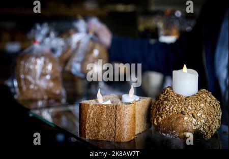 2022-10-22 14:04:53 BUSSUM - Ein Bäcker hat das Licht im Geschäft ausgeschaltet und Kerzen angezündet. Dies ist aus Protest gegen das vom Kabinett vorgeschlagene Energieausgleichssystem. ANP KOEN VAN WEEL niederlande Out - belgien Out Stockfoto