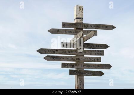 Schilder auf einem Holzpfosten in der Nähe des Strandes zu interessanten Zielen auf der Dutch Wadden Island von Texel. Stockfoto