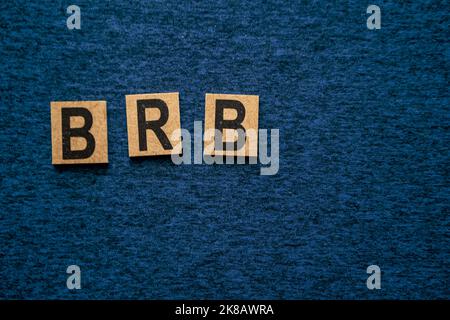 Die Buchstaben b r b in Holzblöcken auf einem neutralen blauen Hintergrund Abkürzung für rechts zurück geschrieben Stockfoto