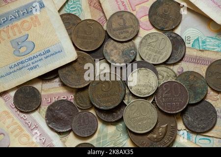 Auf dem Tisch liegen die Währungseinheit des ukrainischen Staates Kupon und Münzen der udssr, altes sowjetisches Geld, Münzen und Kupons, Finanzen Stockfoto