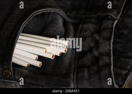 Zigaretten in einer Tasche in grauen Jeans, Zigarettensucht und Mode, Rauchen Stockfoto