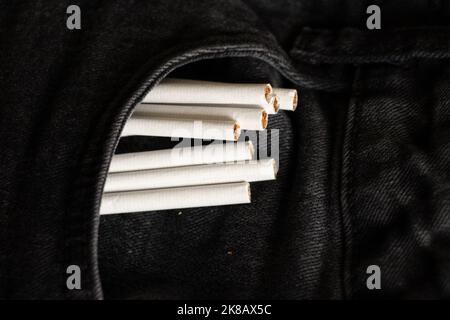 Zigaretten in einer Tasche in grauen Jeans, Zigarettensucht und Mode, Rauchen Stockfoto