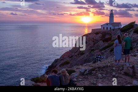 Paare beobachten den Sonnenaufgang am Kap Capdepera auf der Insel Mallorca Stockfoto