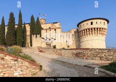 Kopfsteinpflasterstraße, die über die Zugbrücke (Ponte Levatoio) zum Schloss von Brescia führt, und Turm der Gefangenen (Torre dei Prigionieri) auf der rechten Seite Stockfoto