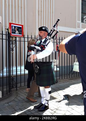 Die schottische Piper beklagt sich, als die Menschen aus einer Trauermesse für Königin Elizabeth 2 in der Kathedrale auf dem Felsen von Gibraltar aussteigen Stockfoto