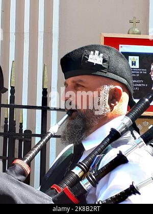 Die schottische Piper beklagt sich, als die Menschen aus einer Trauermesse für Königin Elizabeth 2 in der Kathedrale auf dem Felsen von Gibraltar aussteigen Stockfoto