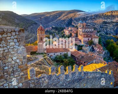 Blick auf Albarracin bei Sonnenuntergang mit seinen Mauern und die Kirche Santa Maria y Santiago im Vordergrund. Teruel, Spanien. Stockfoto