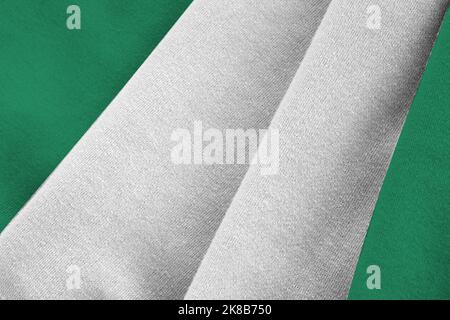 Nigeria Flagge mit großen Falten winken aus nächster Nähe unter dem Studiolicht im Innenbereich. Die offiziellen Symbole und Farben in Stoff Banner Stockfoto