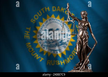 US-Staatsflagge von South Dakota mit einer Statue der Justizdame und einer Justizwaage in einem dunklen Raum. Konzept von Urteil und Strafe, Hintergrund für Jury topi Stockfoto