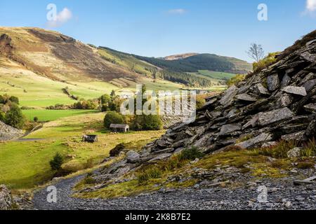 Schieferweg durch Rhiw Fachno Steinbruch Schlackenhaufen über dem Dorf im Tal in Snowdonia. CWM Penmachno, Betws-y-Coed, Conwy, North Wales, Großbritannien, Großbritannien Stockfoto