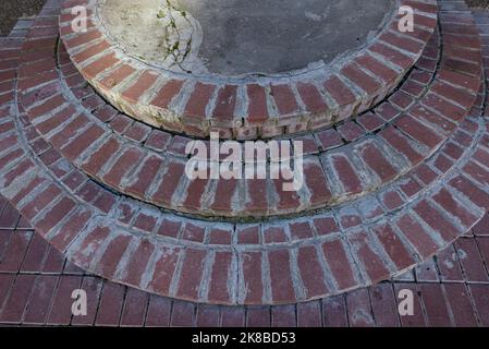 Alte Ziegeltreppe mit heruntergefallenen Blättern nach dem Regen. Stockfoto