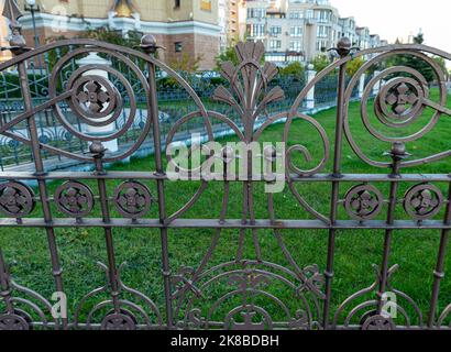 Zaun, schmiedeeiserner Zaun, Schmieden und Stein, schmiedeeiserne Ornamente, horizontales Foto Stockfoto