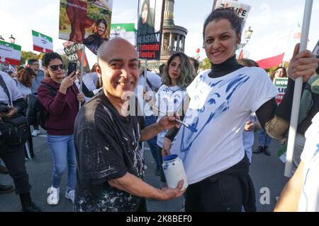 Berlin, Deutschland. 22. Oktober 2022. Die deutsch-iranische Künstlerin Kani Alavi malt T-Shirts auf einer Solidaritätsdemonstration für Demonstranten im Iran am Großen Stern. Ausgelöst wurden die Massenproteste im Iran durch den Tod der 22-jährigen iranischen Kurdin Amini Mitte September. Quelle: Jörg Carstensen/dpa/Alamy Live News Stockfoto