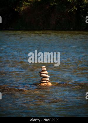 Pyramidensteine balancieren auf dem Fluss bei Ladakh. Das Objekt ist fokussiert, der Hintergrund ist unscharf. Stockfoto