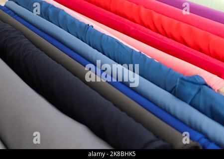 Muster von Stoffen und Stoffen in verschiedenen Farben, die auf einem Stoffmarkt zu finden sind. Stockfoto