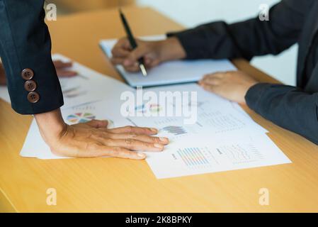 Manager Beratung mit Mitarbeiter in der Macht Art und Weise über Business-Ziel-Problem, Geschäftsberichte Lösungen mit Diagramm, Diagramm, Verkaufsvolumen, Geschäft Stockfoto