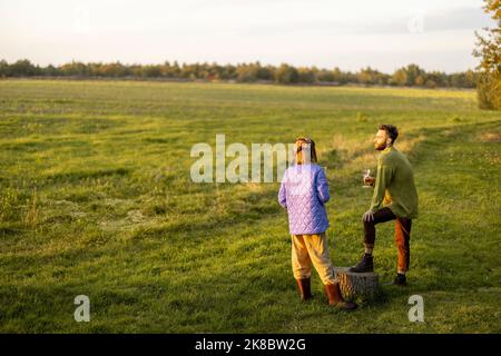 Paare hängen sich während des Sonnenuntergangs in der Natur ab Stockfoto