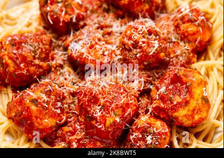 Putenfleischbällchen mit Knoblauch- und Basilikumtomatensauce und Vollkornteigwaren, die mit Parmesan aus nächster Nähe bestreut wurden Stockfoto