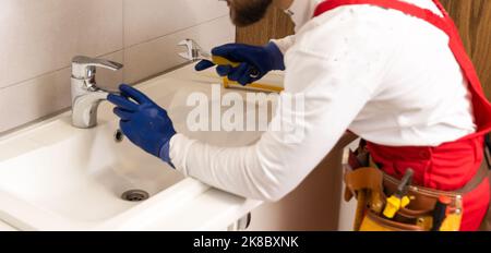 Männer, die im Badezimmer ein Waschbecken befestigten Stockfoto