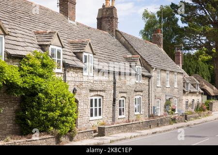 Reihe von alten Steinhäusern, Reihenhäusern in Corfe Castle Village, Dorset Stockfoto
