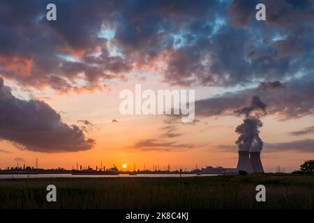 Farbenprächtiger Sonnenuntergang über dem Antwerpener Welthafen in Belgien mit Blick auf die Türme des Atomkraftwerks Stockfoto