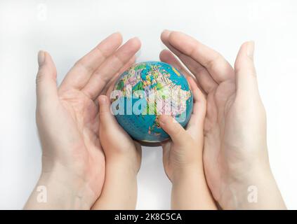 Hände von Mutter und Kind, die einen Globus halten Stockfoto