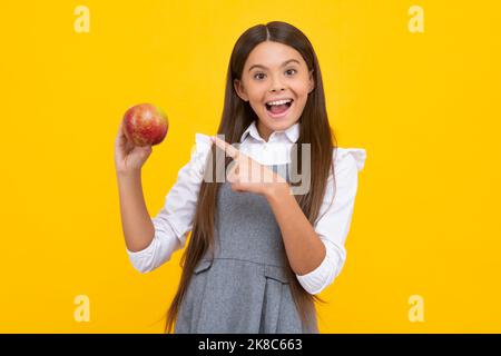 Junge essen grünen Apfel auf gelb isolierten Hintergrund. Äpfel sind gut für Kinder. Aufgeregt Gesicht, fröhliche Emotionen von Teenager-Mädchen. Stockfoto