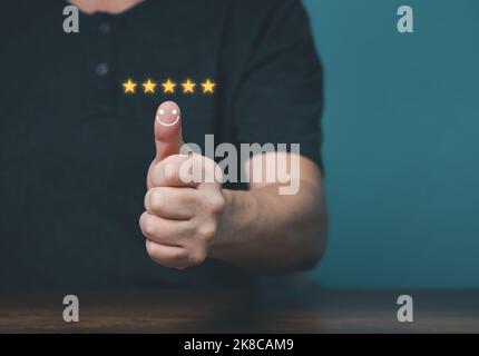 Kundenzufriedenheitskonzept, Hand mit Daumen nach oben positive Emotion Smiley Face Symbol und fünf Sterne mit Copy Space. Stockfoto