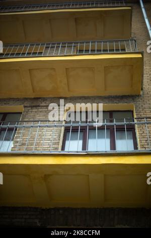 Offene Balkone. Balkone ohne Verglasung im Haus. Details des alten Hauses. Fenster in einer Ziegelwand. Stadtentwicklung des 20.. Jahrhunderts. Stockfoto