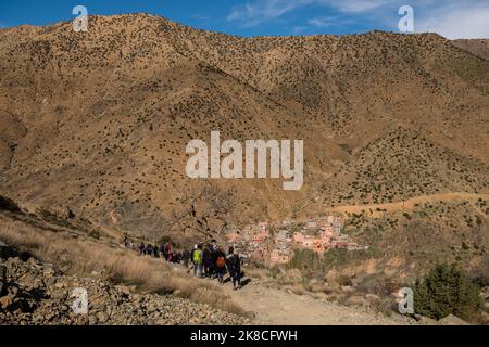 Touristen wandern im Atlasgebirge mit dem alten Dorf Setti Fatma im Hintergrund, Ourika-Tal, Marokko, Nordafrika Stockfoto