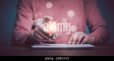Hand berühren Leuchtmittel Leuchtende Leuchtmittel und SMS auf der Tastatur, neue kommen Idee mit Innovation und Inspiration, innovative Technologie Stockfoto