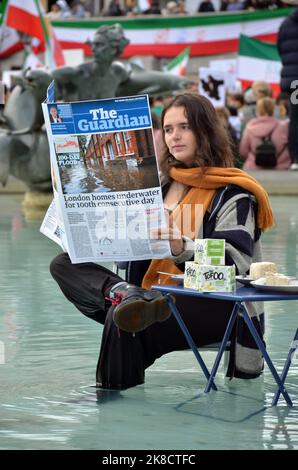 London, Großbritannien. 22. Oktober 2022. Protest der Tieraufstände gegen Klappstühle im Trafalgar Square-Brunnen, der gefälschte Guardian-Zeitungen las, nachdem die ehemalige Innenministerin Suella Braverman Öko-Demonstranten als ‘Hüterfressende, Tofu-fressende, Wokerati' bezeichnete. Protest gegen den Tod von Mahsa Amini im Iran im Hintergrund. Kredit: JOHNNY ARMSTEAD/Alamy Live Nachrichten Stockfoto