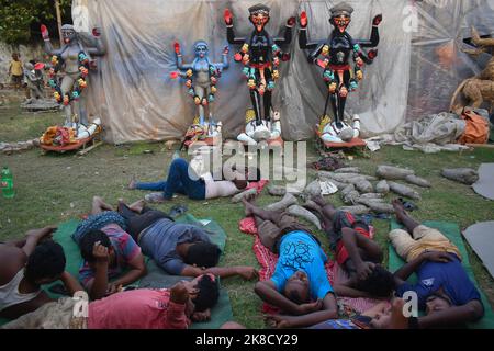 Kalkutta, Westbengalen, Indien. 22. Oktober 2022. Arbeiter ruhen vor Kali-Idolen in einer Straßenwerkstatt in Kalkata. Kredit: ZUMA Press, Inc./Alamy Live Nachrichten Stockfoto