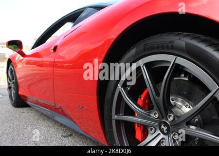 Das Hinterrad-Abzeichen auf dem Hinterrad mit rotem Bremssattel eines Ferrari 458 Italia aus dem Jahr 2015 Stockfoto