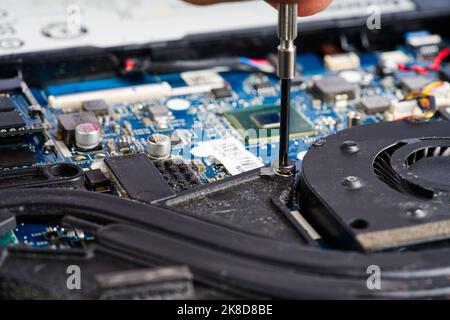 Mann zerlegt einen Laptop. Computer-Service- und Reparaturkonzept. Demontage des Laptops in der Werkstatt Stockfoto