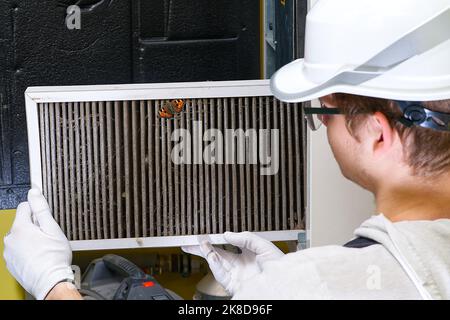 hlk-Filter Ersatz Home zentrale Luftanlage. Servicemenwechsel Filter im Ofen. Stockfoto