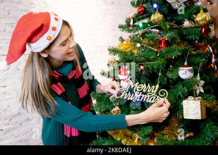 Glücklich kaukasische junge Frau Dekoration und Vorbereitung Ornament auf Weihnachtsbaum mit zu Hause genießen, weibliche Dekoration Festival Weihnachten mit aufgeregt und Stockfoto