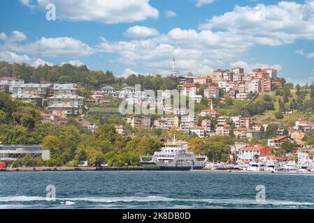 Blick vom Meer auf die grünen Berge der asiatischen Seite der Bosporus-Meerenge, mit traditionellen Häusern und dichten Bäumen an einem Sommertag Stockfoto