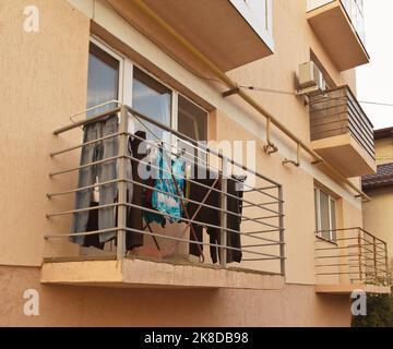 Trocknen der Kleidung auf dem Balkon der Wohnung im unteren Stock Stockfoto