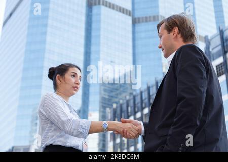 Professionelle amerikanische Geschäftsmann und junge asiatische Geschäftsfrau Händedruck in der Unternehmenszentrale nach Erfolg in Vereinbarung über Geschäfts-und Finanz-dea Stockfoto
