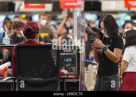 Bangkok, Thailand - 26. Oktober 2022 : Asian Passenger using Smartphone to Check in at Airline counter in suvarnabhumi Airport, Thailand. Stockfoto