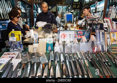 Tokio, Japan - 26. Oktober 2022 : Asiatische Frauen kaufen japanische hochwertige traditionelle Küchenmesser in der lokalen Messerwerkstatt in Tokio, Japan. Stockfoto