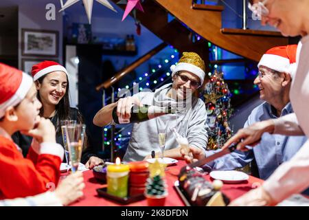 lateinamerikanische Familie mit mehreren Generationen, die zu Hause Weihnachten feiert Stockfoto