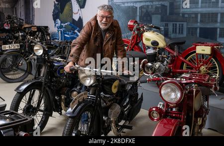 Chemnitz, Deutschland. 04. Oktober 2022. Fahrzeughistoriker und Sammler Frieder Bach steht unter den DKW-Motorrädern im Museum der sächsischen Fahrzeuge. Zufällig war ihm eine Skizze des ersten kompletten Rennmotorrads der Firma DKW in die Hände gefallen. Der Motorrad-Enthusiast hatte genügend Originalteile im Regal. Er brauchte etwa ein halbes Jahr, um die Maschine 1922 wieder zu beleben. (To dpa 'DKW & MZ: Vor 100 Jahren Aufstieg zum größten Motorradhersteller der Welt') Quelle: Hendrik Schmidt/dpa/Alamy Live News Stockfoto