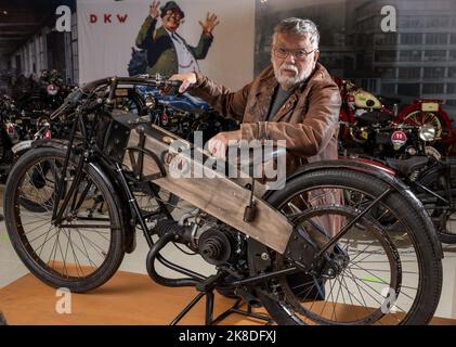 Chemnitz, Deutschland. 04. Oktober 2022. Fahrzeughistoriker Frieder Bach steht im Museum für Sächsische Fahrzeuge an seiner Nachbildung eines DKW-Rennmotorrads. Zufällig war ihm eine Skizze des ersten kompletten Rennmotorrads der Firma DKW in die Hände gefallen. Der Motorrad-Enthusiast hatte genügend Originalteile im Regal. Er brauchte etwa ein halbes Jahr, um die Maschine 1922 wieder zu beleben. (To dpa 'DKW & MZ: Vor 100 Jahren Aufstieg zum größten Motorradhersteller der Welt') Quelle: Hendrik Schmidt/dpa/Alamy Live News Stockfoto