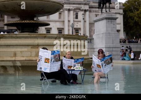 London, Großbritannien. 22. Oktober 2022. Aktivisten sahen, wie sie einen gefälschten The Guardian mit einem Tofu-Tisch im Brunnenbereich am Trafalgar Square lasen. Aktivisten von Animal Rebellion haben eine Performance Arts am Brunnen auf dem Trafalgar Square inszeniert, als Reaktion auf das Zitat der ehemaligen Innenministerin Suella Braverman im britischen Parlament, das „Guardian-reading, tofu-eating wokerati“ zitiert wurde. Kredit: SOPA Images Limited/Alamy Live Nachrichten Stockfoto