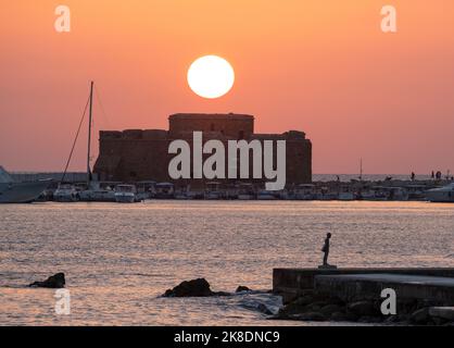 Die Sonne untergeht über dem Fort von Pafos, dem Hafen von Pafos, Zypern. Stockfoto