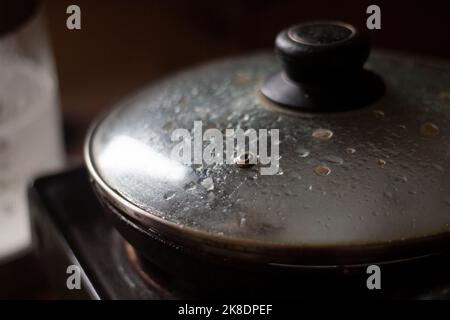 Bratpfanne in der Küche. Deckel auf der Bratpfanne. Kochen. Schmutziges Geschirr. Stockfoto