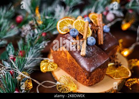 Neujahrskuchen mit zart cremigem Teig und Rosinen, verziert mit Gewürzen, Heidelbeeren und getrockneten Orangenscheiben Stockfoto