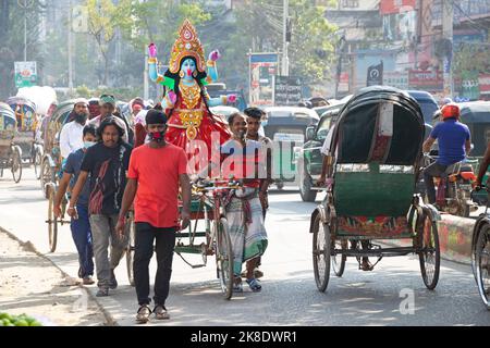 Narayanganj, Dhaka, Bangladesch. 23. Oktober 2022. Eifrige Anhänger transportieren ein Idol der Hindu-Göttin Kali auf einem Rikscha-Van zu einem Ort der Anbetung vor dem Shyama Puja-Fest in Narayanganj, Bangladesch. Die Göttin Kali wird als Retter von aller bösen Kraft, von Dämonen und einer Quelle der Macht, von Glück, wie es die Hindu-Mythologie darstellt, verehrt. (Bild: © Joy Saha/ZUMA Press Wire) Stockfoto